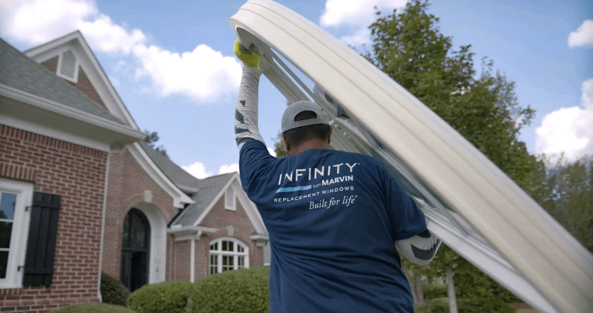 An Infinity from Marvin window installer hauls a round top window.