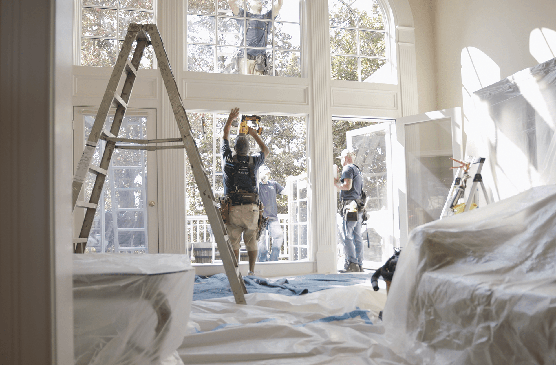 A team of Infinity installers work to replace windows inside a home.