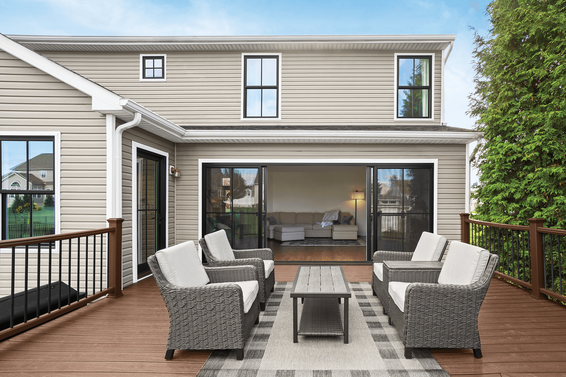 Exterior view of a deck with an opened black four-panel patio door.