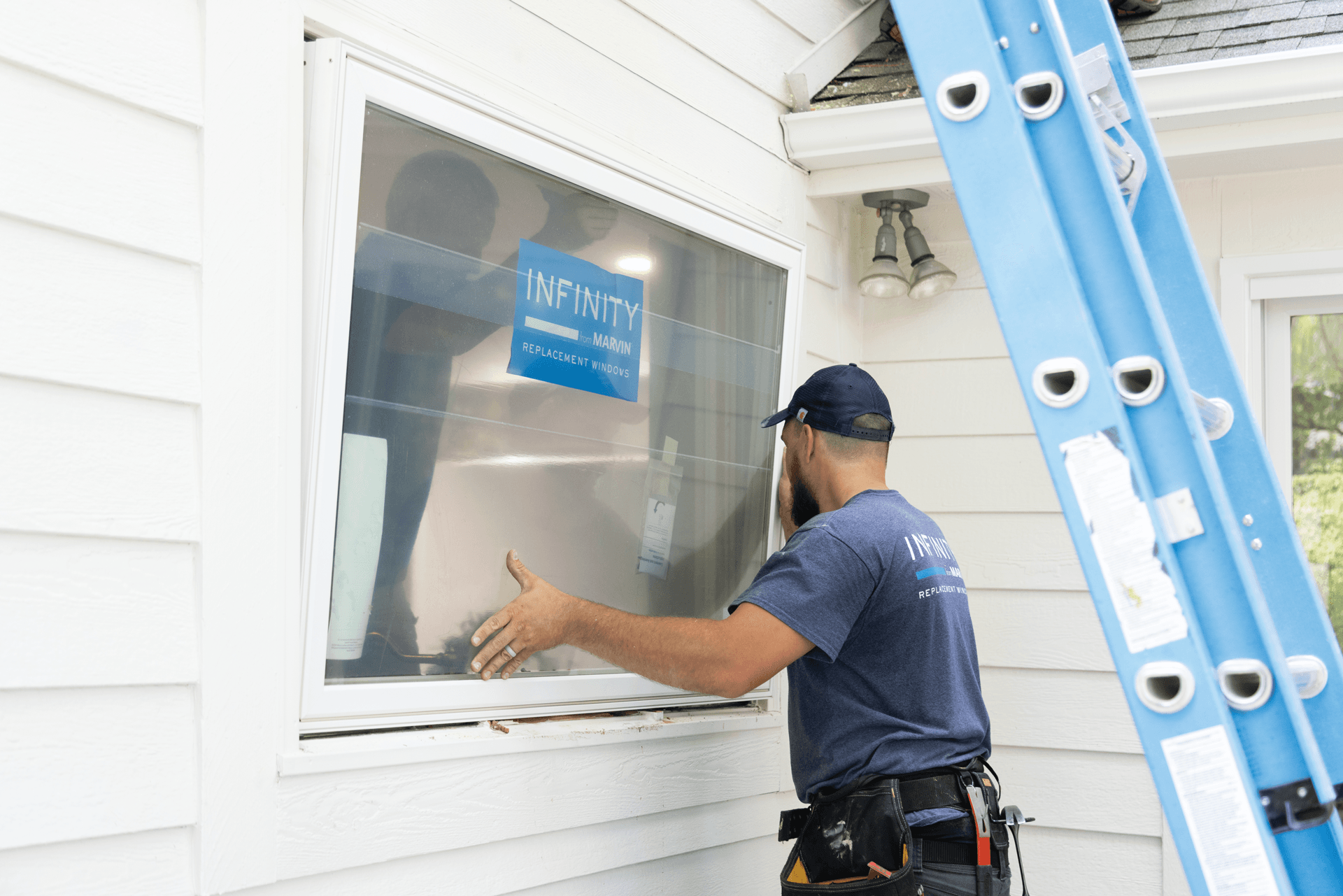 A man installing an Infinity from Marvin window.