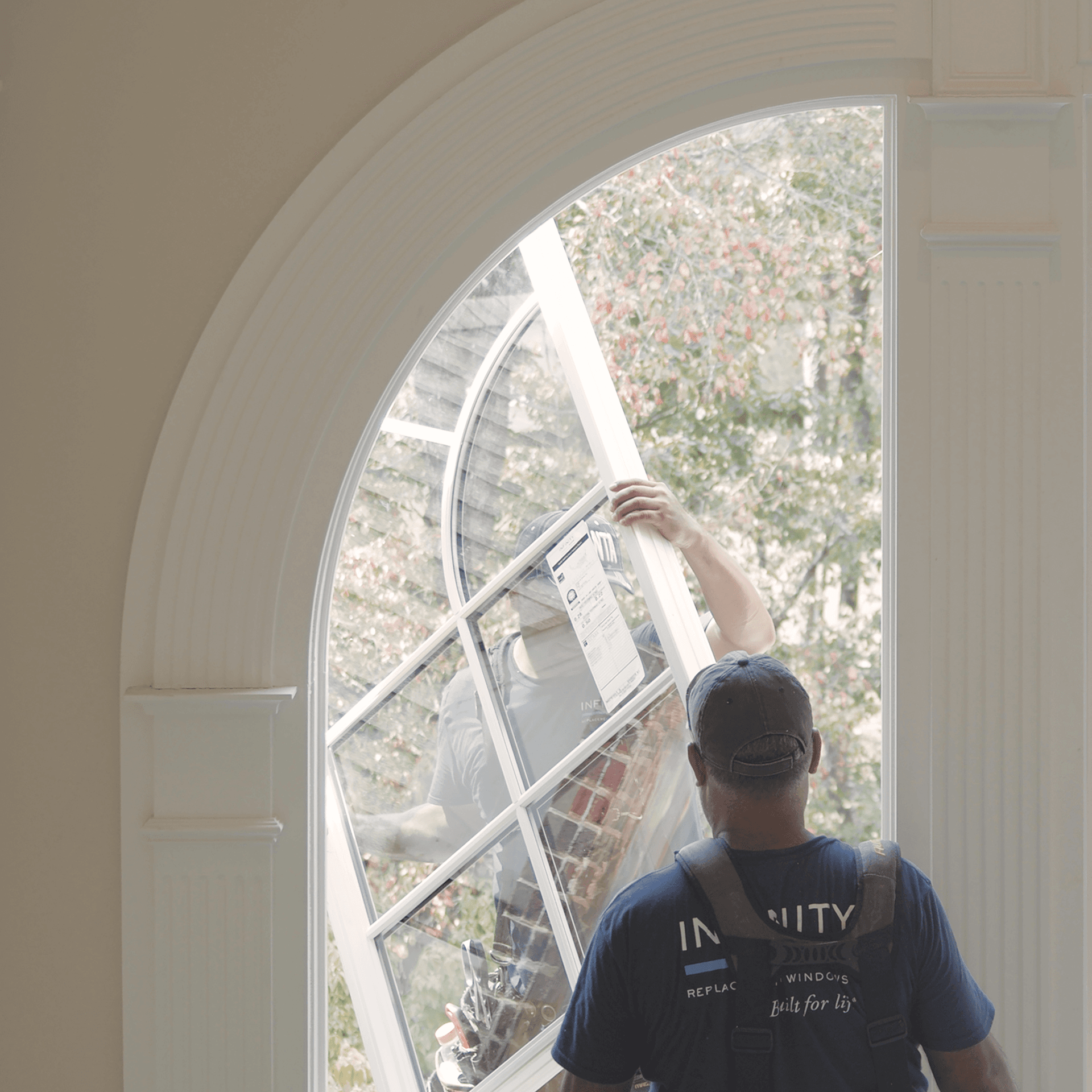 Infinity window installers work to install an arch window.